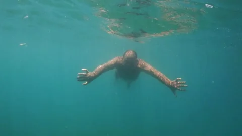 Slow-motion underwater view of man swimming toward camera, smiling Vídeos de archivo 279426295