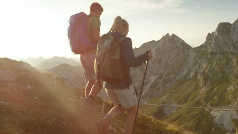 SLOW MOTION: Unrecognizable man and woman hiking downhill in the scenic Alps. Stock Footage 101929064