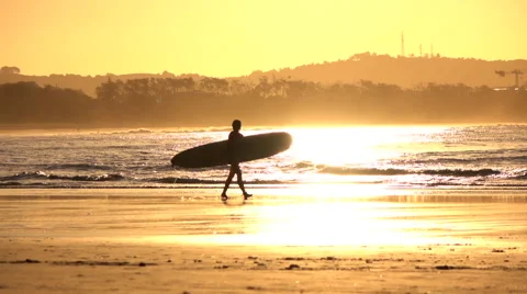 SLOW MOTION: Unrecognizable surfer girl carrying longboard surf at golden sunset Stock Footage