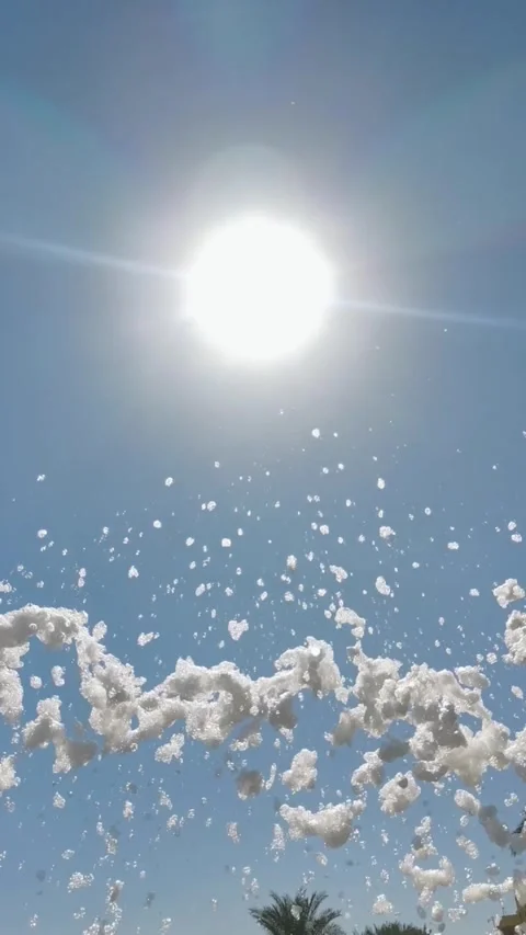 Slow motion upward pan of foam bubbles rising and scattering over resort po.. Stock Footage 329871139