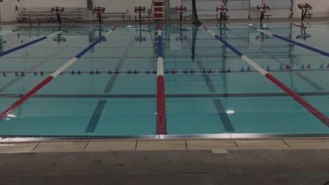 Slow Motion Upward Pan Over Empty Indoor Olympic Swimming Pool Stock Footage 324699393