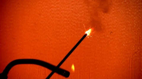 Slow motion - Using a portable lighter flame to light a sparkler. Stock Footage 103091946