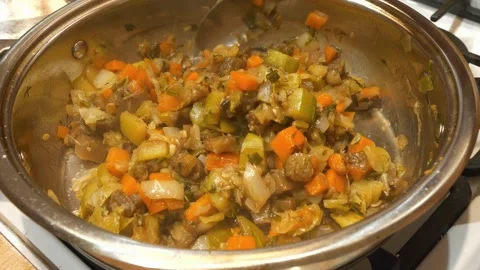Slow Motion. Vegetable stew is cooked on a stove. Ragout is cooked in metal pan Video stock 323084546