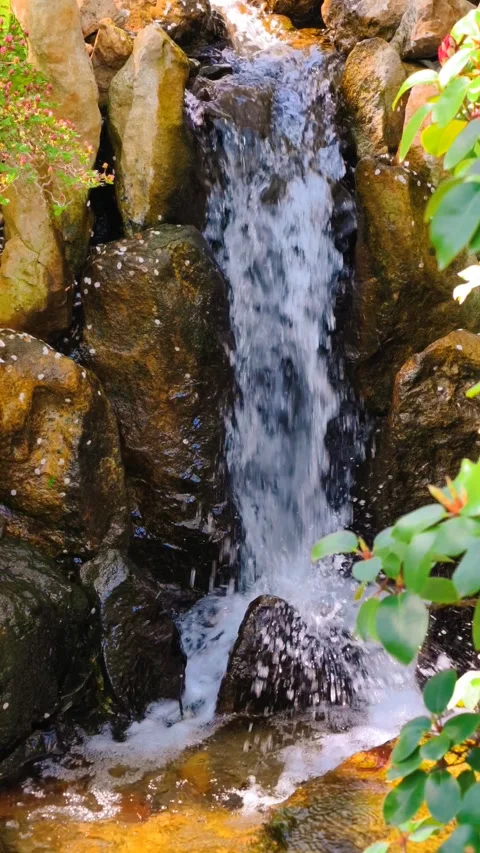 Slow motion vertical cinematic 4K B-roll footage waterfall cascades sunlit rocky Stock Footage 307431997