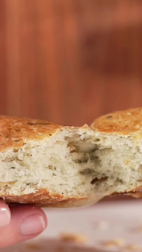Slow motion vertical close-up of hands tearing whole grain bun with spinach.. Stock Footage 312169493