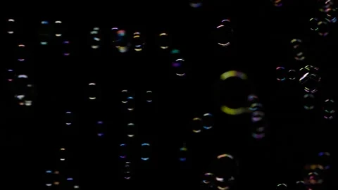 Slow motion of vertical soap water bubbles texture flying over black background Stock Footage 181796182