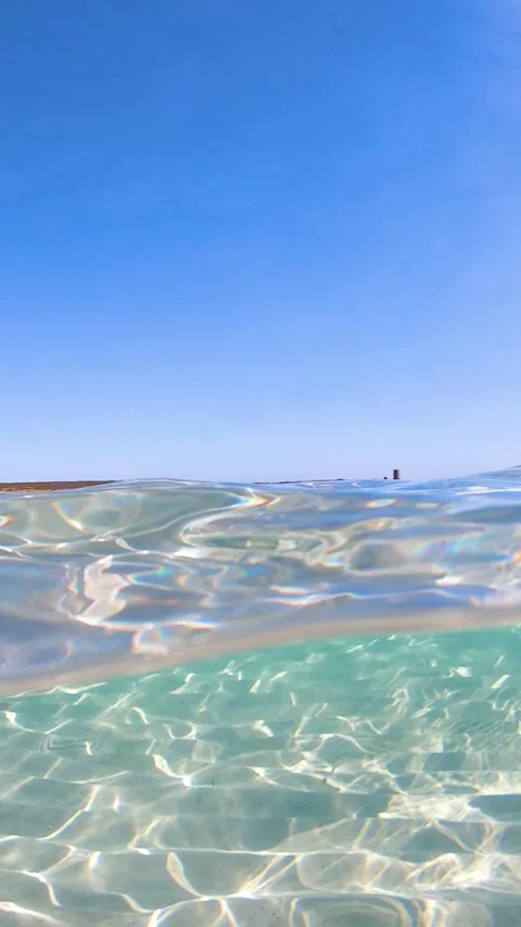 Slow motion vertical split underwater view at La Pelosa Beach Sardinia Stock Footage 339775814