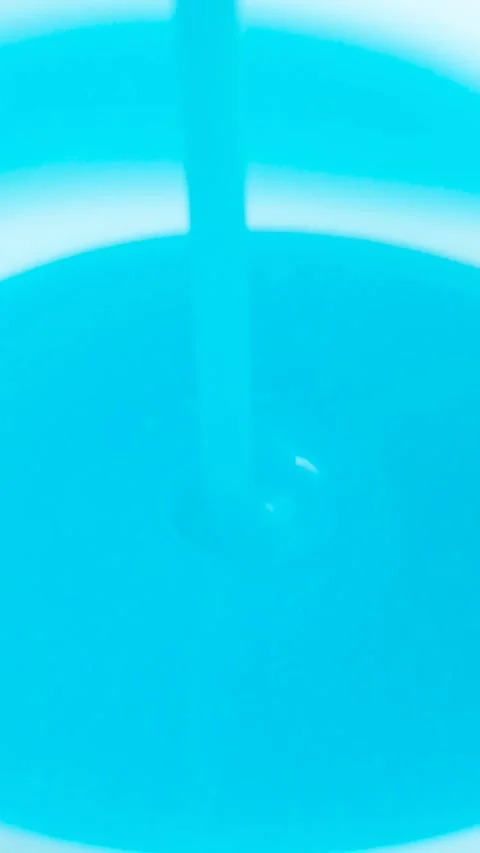 Slow motion vertical of thick blue liquid laundry detergent pouring. Stock Footage 337182248