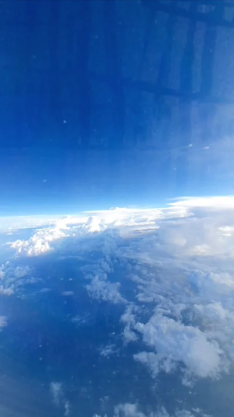Slow motion vertical video from aircraft window flying above soft white clouds u Stock Footage 331888158