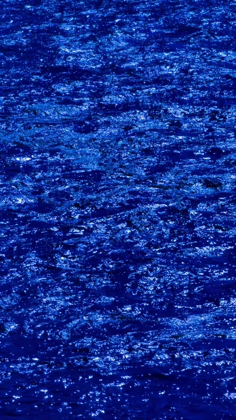 Slow motion vertical video of deep blue water surface shimmering in sunlight. Stock Footage 305927764