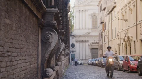 Slow motion Vespa motorcycle passing by camera Italy side street Stock Footage
