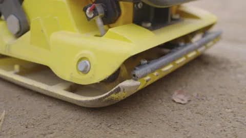 Slow Motion Vibratory Plate Compactor on Sand Stock Footage 164468038