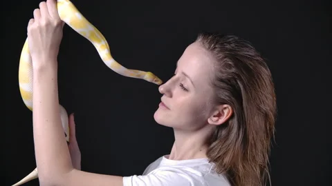 Slow motion video of albino python kissing blond woman Stock-Footage 144480480