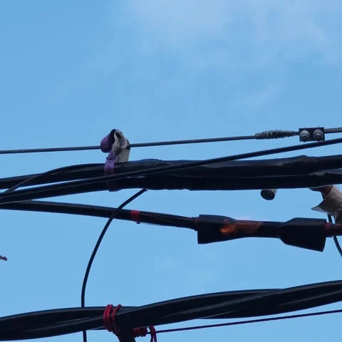 Slow motion video of applying heat to shrink a joint on twisted aerial. Stock Footage 345128693