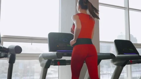 Slow-motion video. The athlete in training runs on a treadmill, twisted from Stock Footage 134916404