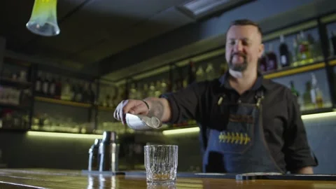 Slow motion video of a bartender pouring ice into a glass. Stock-Footage 230646002