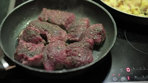 Slow motion video of Big fat juicy steaks in a pan, seasoned, ready to be Stock Footage 302400124