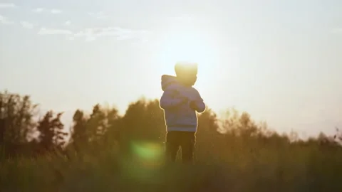 Slow motion video of a boy running across a field at sunset. Stock Footage 211652738
