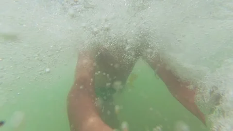 Slow motion video of a boy running along the beach and jumping into the sea on a Stock Footage 317321515