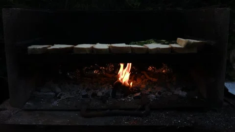 Slow motion video of bread slices cooking sun a barbecue made with a black slate Stock Footage 160427269