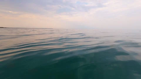 Slow motion video of calm evening sea with gentle ripples and soft pastel Stock Footage 317302096