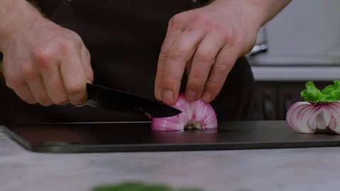 Slow motion video of a chef chopping onions. Close-up of a kitchen knife cutting Видео 269120462