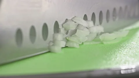 Slow-motion video of a chef cutting an onion with a knife on a board. Stock Footage 227219795