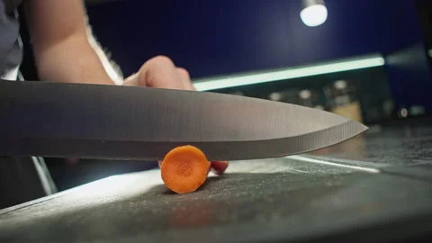Slow motion video close-up of cutting carrots into circles on a cutting board. Stock Footage 220924898