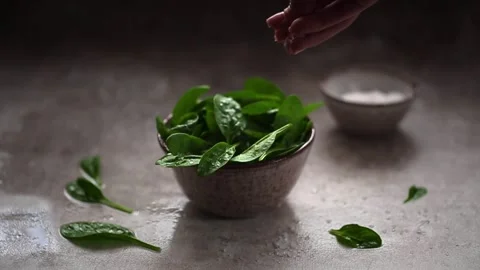 Slow Motion video of Coarse salt falling on Leaves of fresh baby spinach Stock Footage 162774925