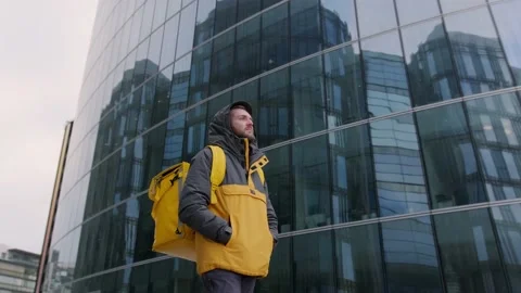 Slow motion video courier with yellow thermo backpack going to deliver parcel or Stock Footage
