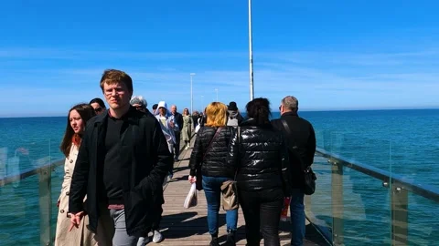 Slow motion video, a crowd of people are walking along the pier Vidéo 194856097