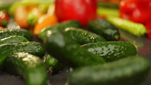 Slow motion video of cucumbers falling with vegetables background. Stock Footage 296362327