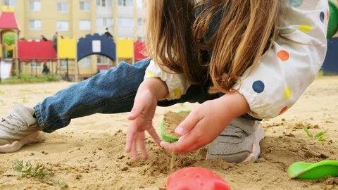 Slow motion video of cute child girl playing with toys in sandbox at playground Stock Footage 280209976