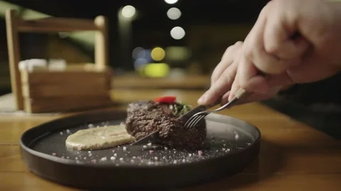 Slow motion video of cutting a piece of steak with a knife in a restaurant. Stock Footage 237620408