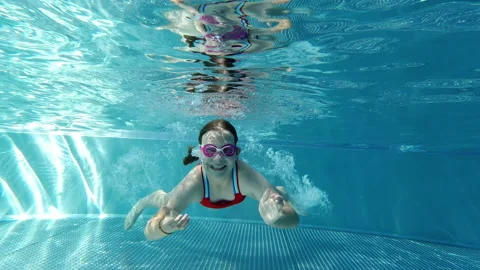 Slow motion video of diving little girl making bubbles underwater in swimming Video stock 201779896