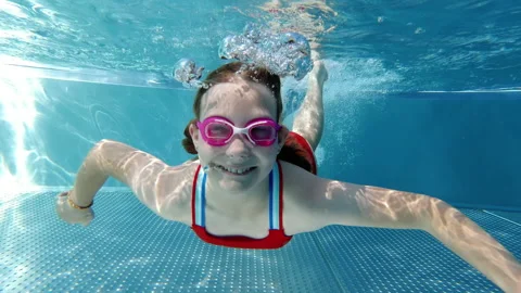 Slow motion video of diving little girl making bubbles underwater in swimming Video stock 201781755