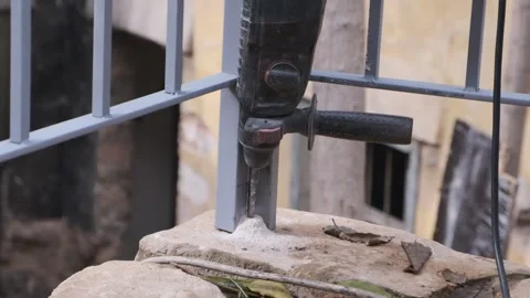 A slow-motion video of a drill piercing through a stone floor Stock Footage 232382517