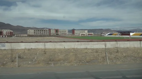 Slow motion video driving past a school in remote location in Tibet 動画素材 113010355
