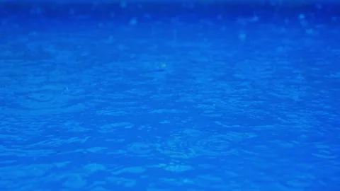 Slow motion video with droplets. Raining on a blue water. Stock Footage 193600228
