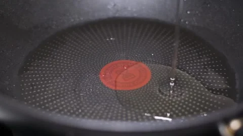 Slow motion video of an egg falling onto a hot pan. Cooking an egg on the stove Stock Footage 253066509