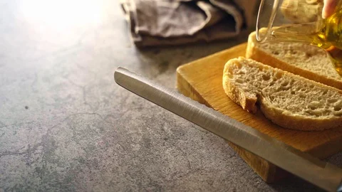 Slow motion video of extra virgin olive oil falling on a slice of bread. Conc Stock Footage 128059980