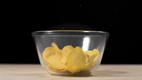 Slow motion video of falling groved potato chips to the glass bowl, groved fried Stock Footage 104898848