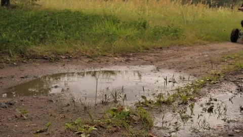 Slow motion video. In the forest, a child enjoys riding an ATV through puddles Stock Footage 252086549