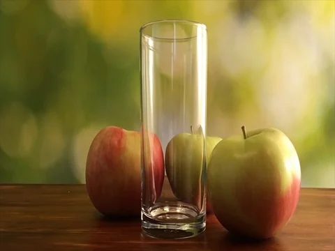 Slow motion video of green apple juice pouring into glass on green background Stock Footage 75682252