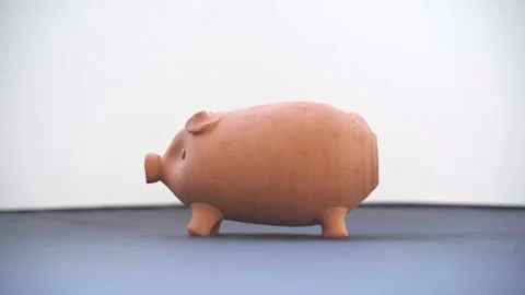 Slow motion video of a hammer hitting and breaking a piggy bank to get the mo Stock Footage