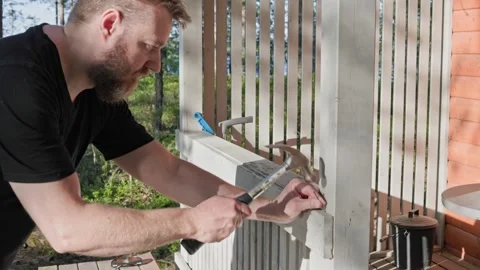 Slow motion video of hammering a nail into the wooden wall of an outdoor sauna. Stock Footage 344903119