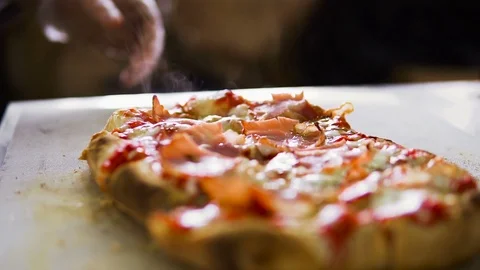 Slow motion video. The hand of the chef sprinkles spices on the pizza Video stock 103203702