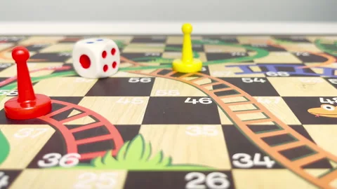 Slow motion video of a hand rolling a dice on a board game. Board game with Stock Footage 313203270