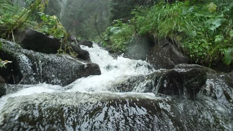 A slow-motion video of how a fast mountain river flows. Crystal clear water. Stock Footage 213018454