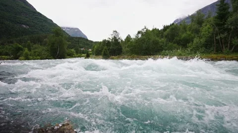 Slow motion video of how a fast mountain river flows. Crystal clear water. Stock Footage 221327138